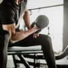 man doing concentration curls exercise working out with dumbbell